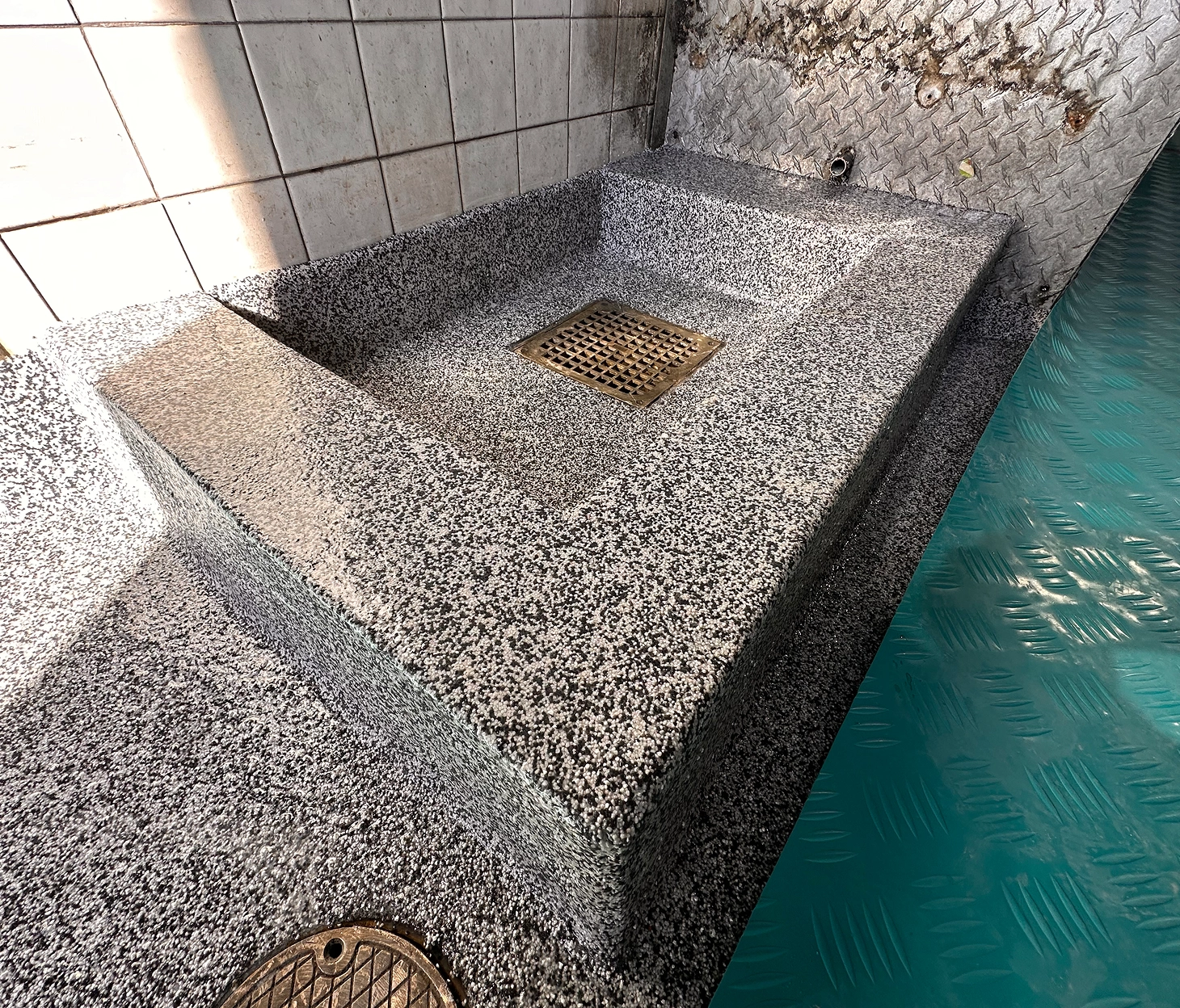 Custom-built epoxy mop sink with flake finish and integrated floor drain in commercial wash area