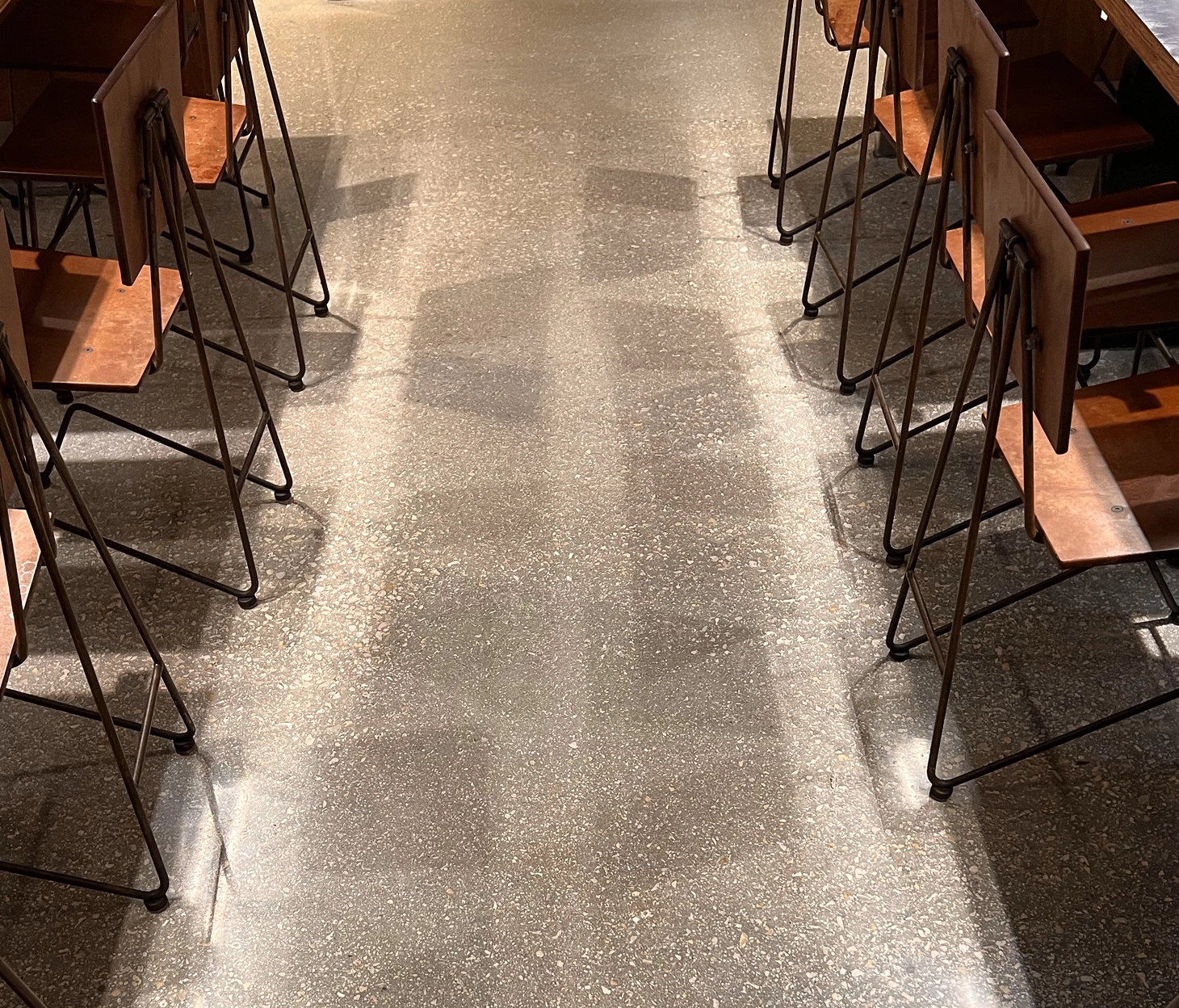 Polished epoxy resin floor with metal-frame wood chairs at Chipotle restaurant