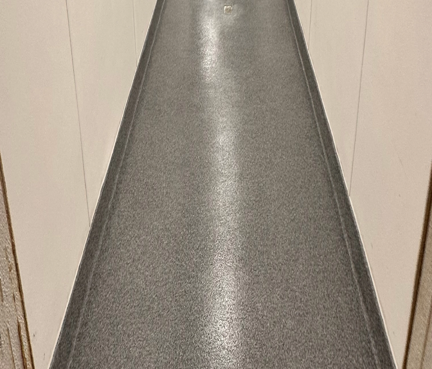 Seamless urethane cement floor in a commercial corridor with integral cove base and sanitary wall finish