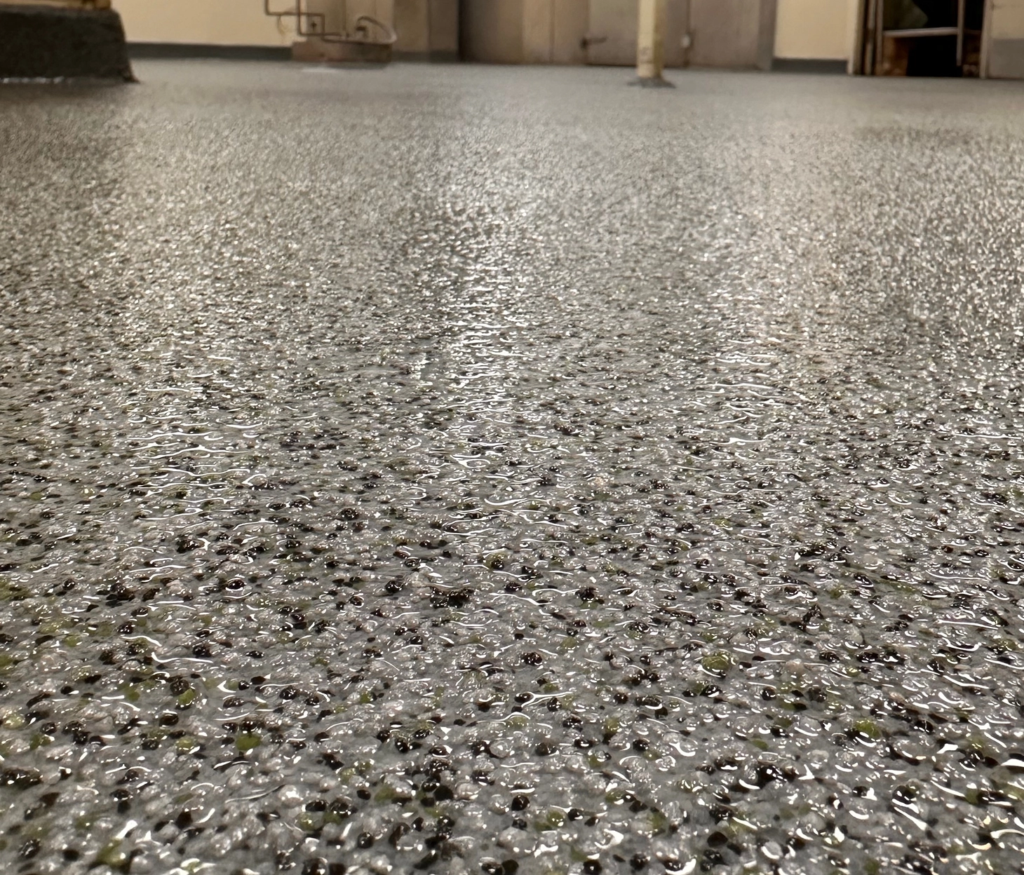 Close-up of freshly installed urethane cement floor with broadcast aggregate texture in a commercial kitchen