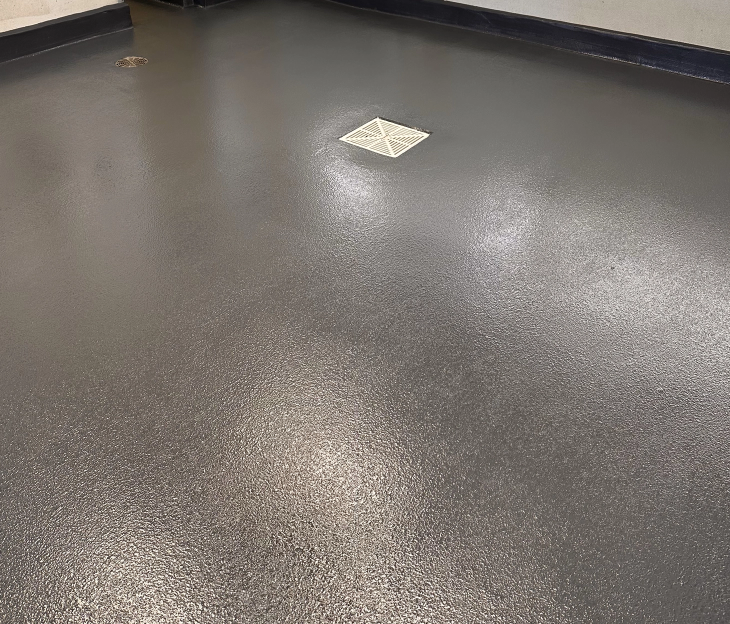Non-slip epoxy floor coating with integrated floor drains in a commercial kitchen or back-of-house setting