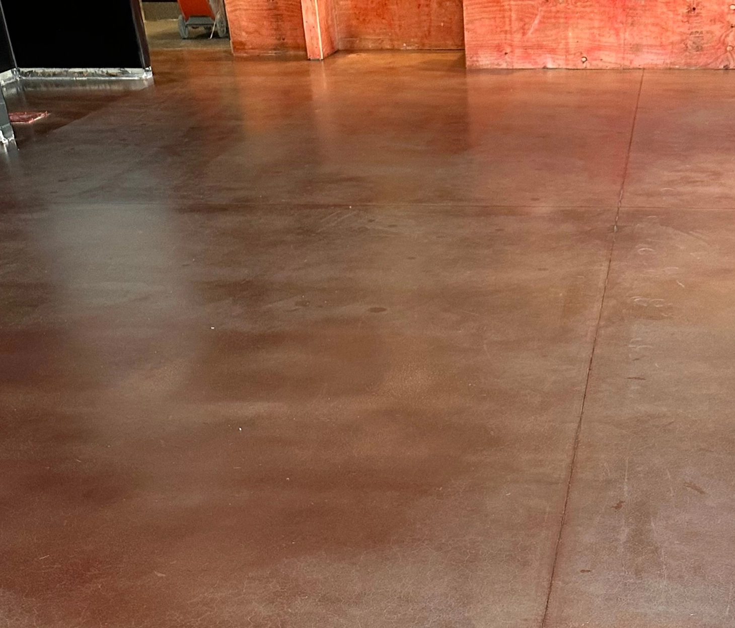 Stained concrete floor with a warm brown finish in a restaurant under construction